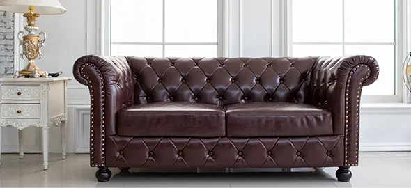 Close-up of a brown leather sofa with tufted details, demonstrating high-quality leather furniture repair in Charlotte, NC