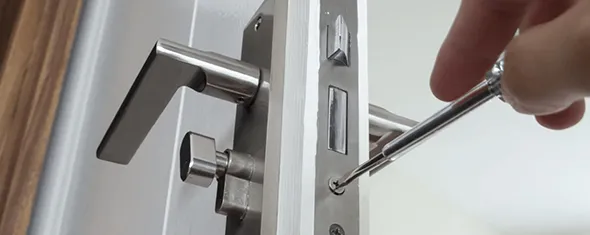Hand using a drill to install a lock on a door, highlighting the benefits of professional lock installation in Weddingon, NC.