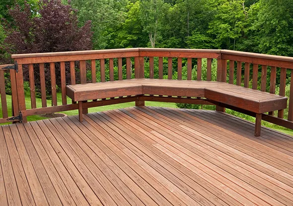 Completed wooden deck with a bench and railing, demonstrating high-quality deck building services in Charlotte, NC