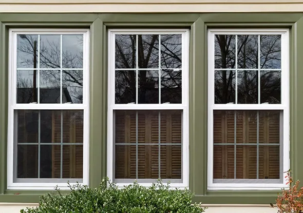 White-framed windows featuring decorative window grilles installed on a residential home in Charlotte, North Carolina.