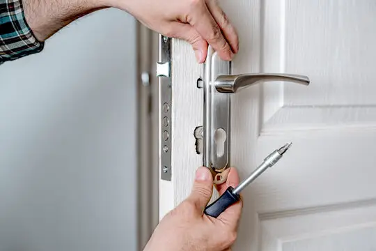 The worker is installing lock in Weddington, NC.